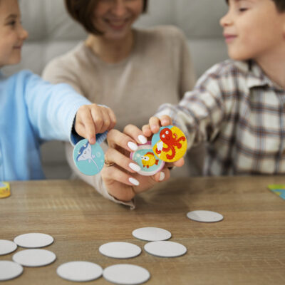 madre con bambini che giocano a giochi da tavolo educativi